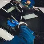 two guys replacing a car windshield